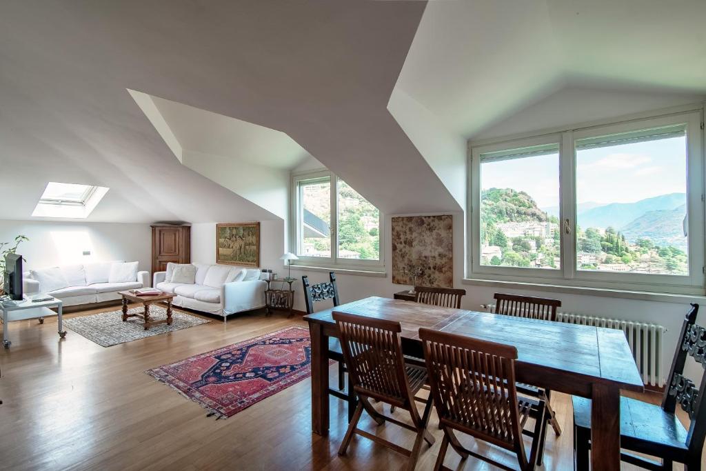 ein Wohnzimmer mit einem Tisch und Stühlen in der Unterkunft I D'A Charming Penthouse - LAKE VIEW in Como