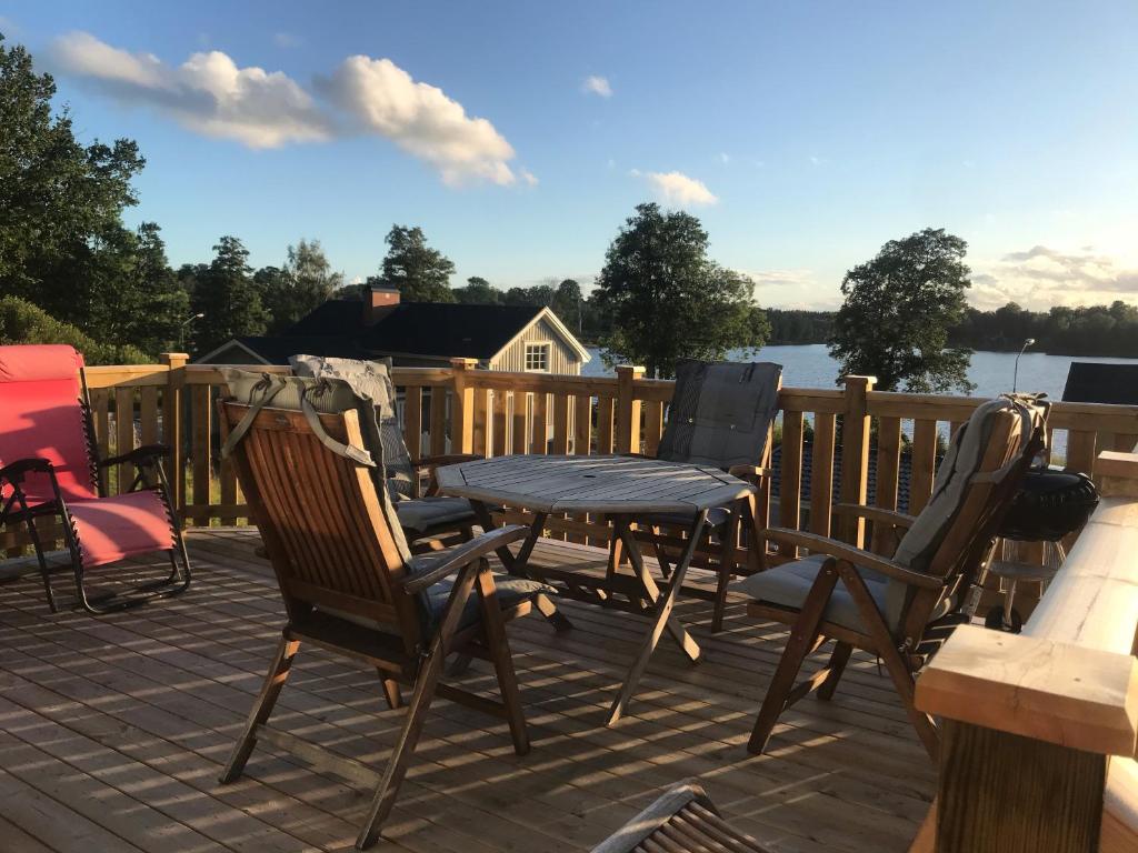 UrshultVälutrustad stuga med vacker sjöutsikt的露台上摆放着椅子和桌子