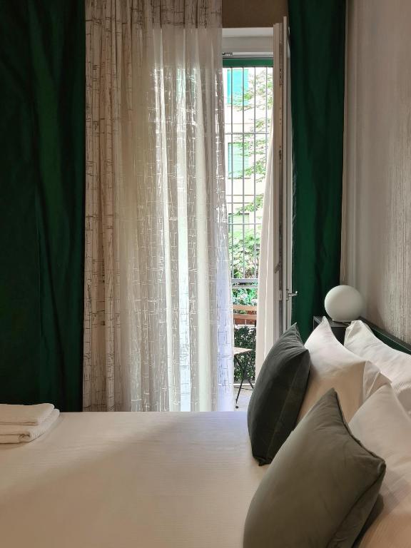 sypialnia z dużym białym łóżkiem i oknem w obiekcie Serendipity Apartments - Montenapoleone w Mediolanie