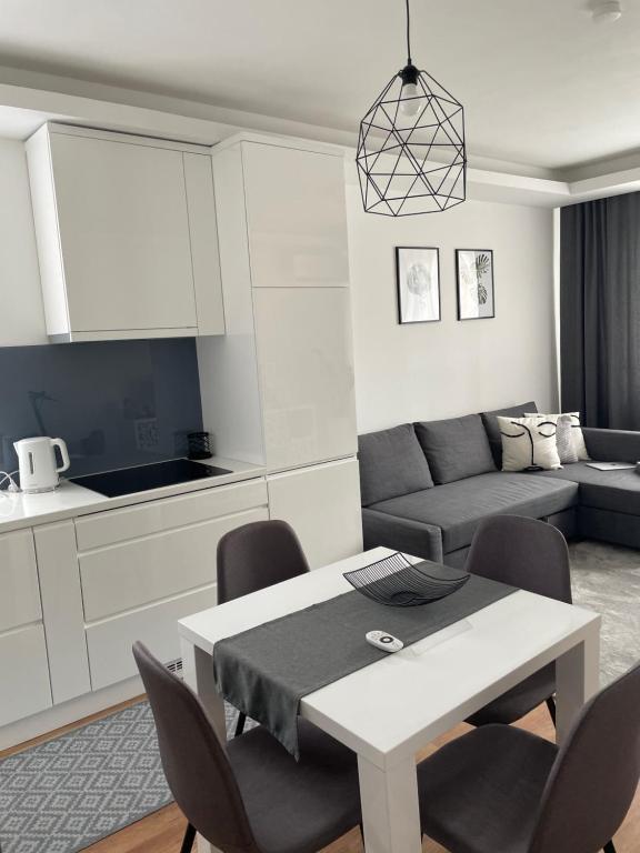 a kitchen and a living room with a table and chairs at BRL Apartman in Nyíregyháza