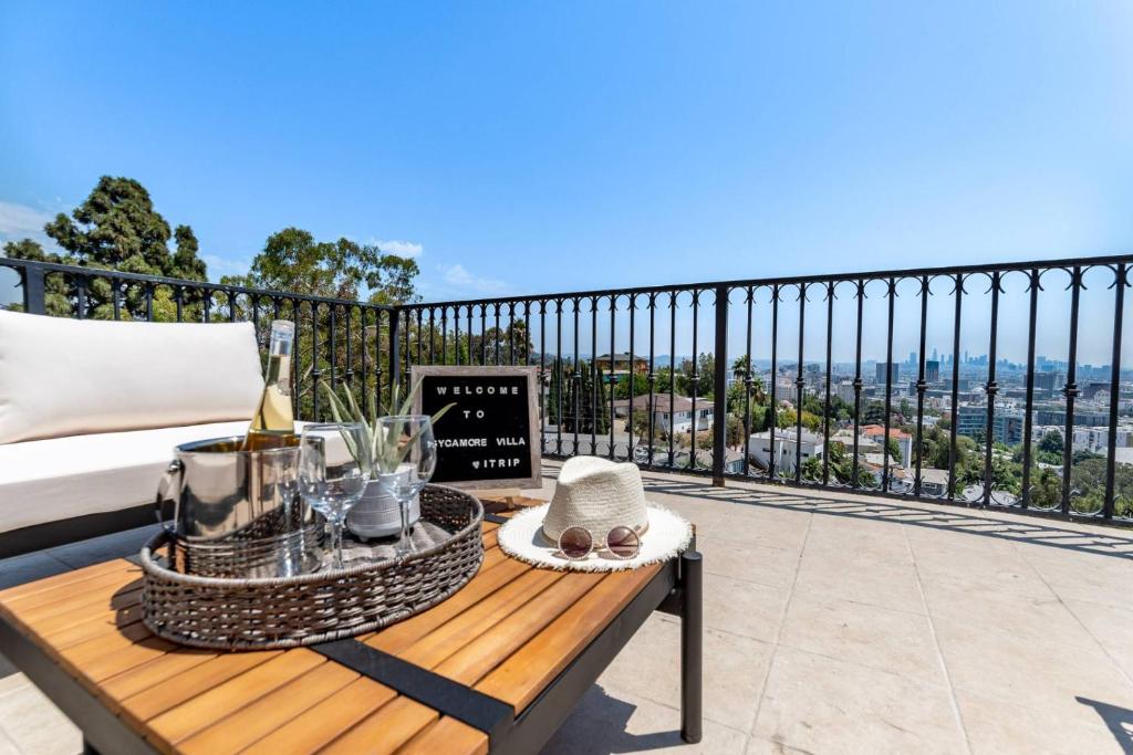 a balcony with a bed and a table with a drink at Sycamore View Villa I in Los Angeles