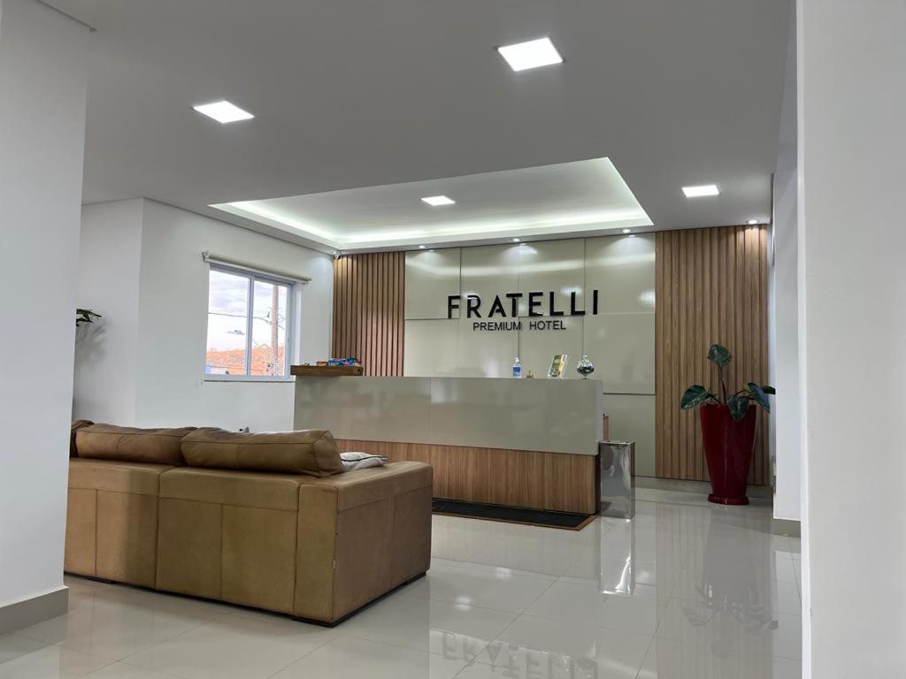 a lobby with a couch in front of a counter at FRATELLI PREMIUM HOTEL in Elói Mendes