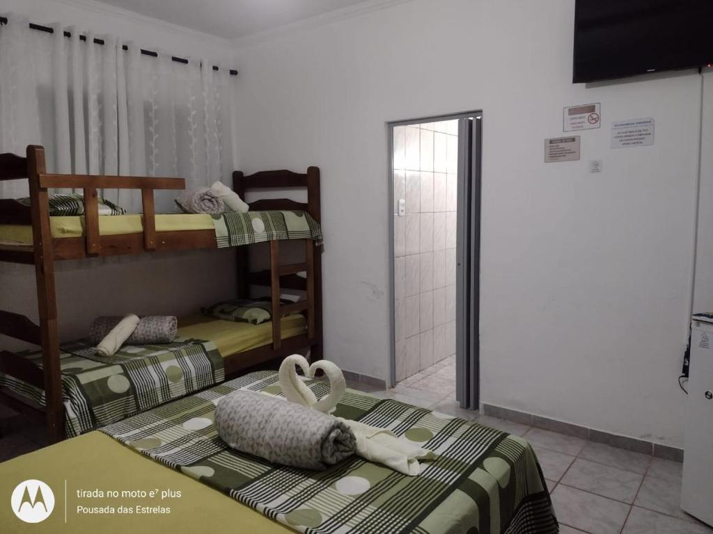 a room with two bunk beds and a shower at Pousada das Estrelas in São Pedro