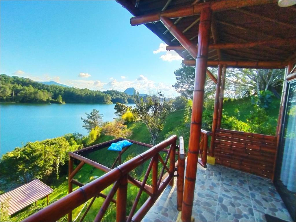 uma varanda de uma casa com vista para um lago em Casa Encuentro Ecolodge em Guatapé