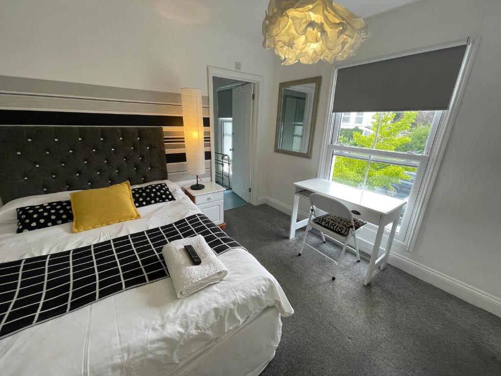 a bedroom with a bed and a desk and a window at Golden Triangle Rooms in Norwich