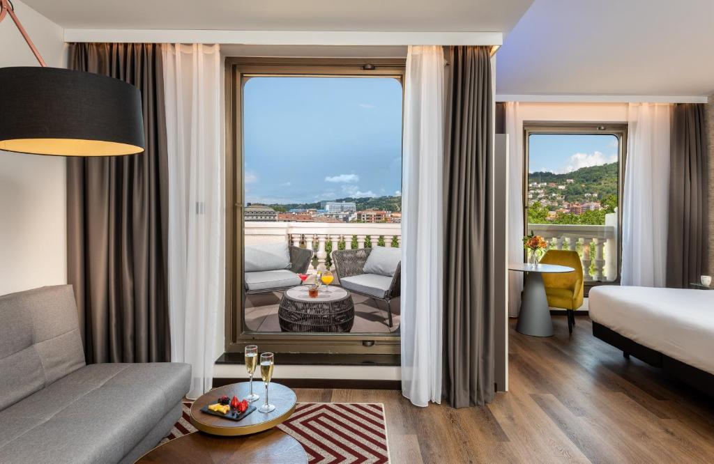 um quarto de hotel com uma cama e uma grande janela em NYX Hotel Bilbao by Leonardo Hotels em Bilbau