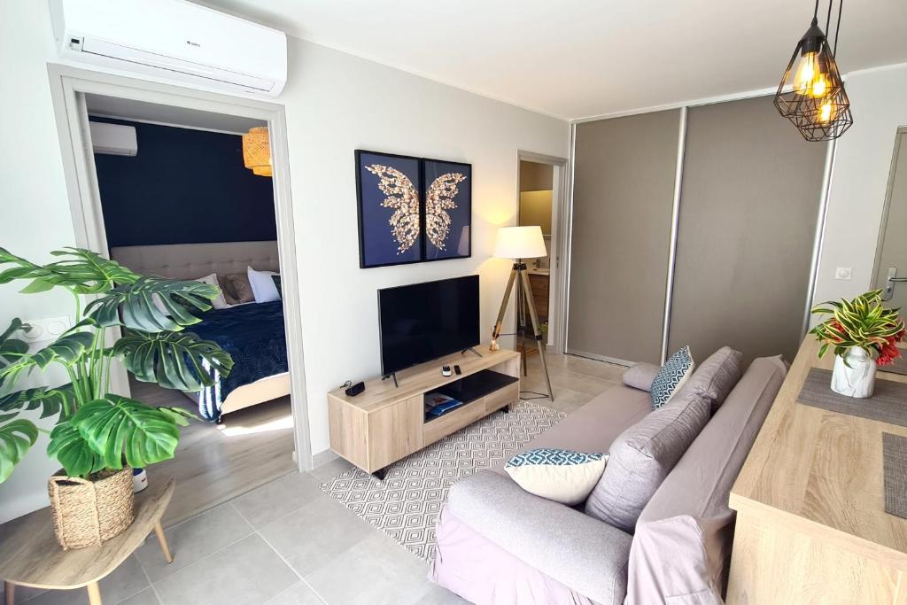 uma sala de estar com um sofá e uma televisão em Hitivai apartment em Papeete