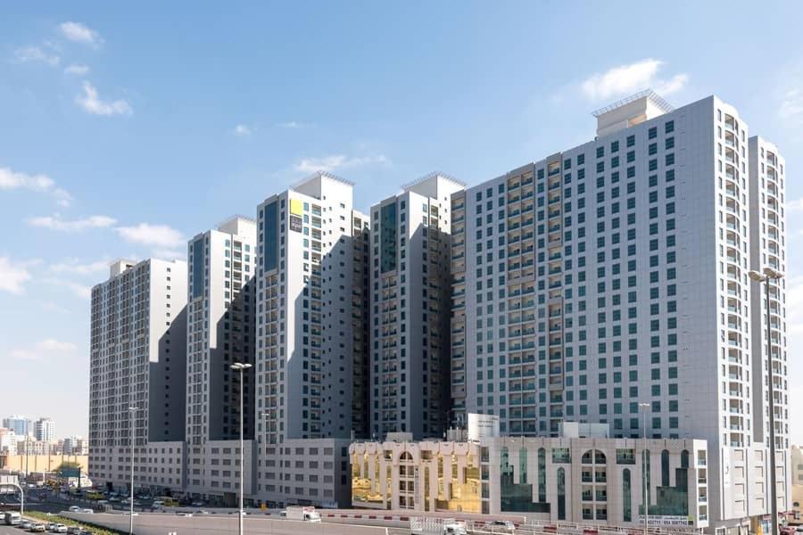 a group of tall buildings in a city at Cheap Holiday Home in Ajman 