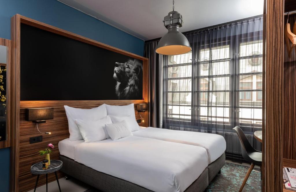 a bedroom with a white bed and a large window at NYX Hotel Prague by Leonardo Hotels in Prague