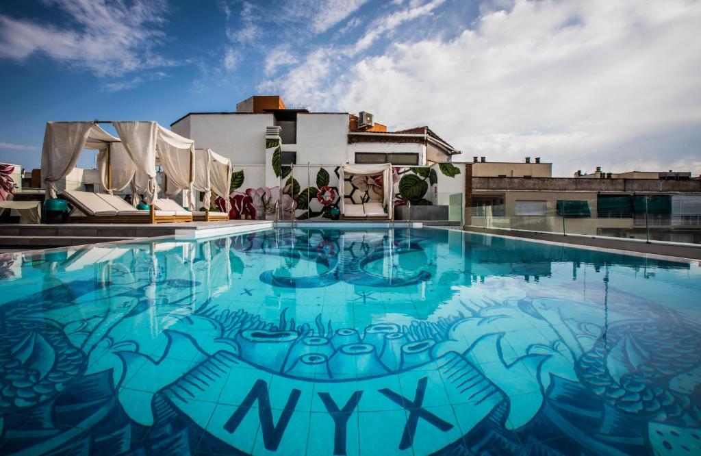 een zwembad met graffiti aan de zijkant van een gebouw bij NYX Hotel Madrid by Leonardo Hotels in Madrid