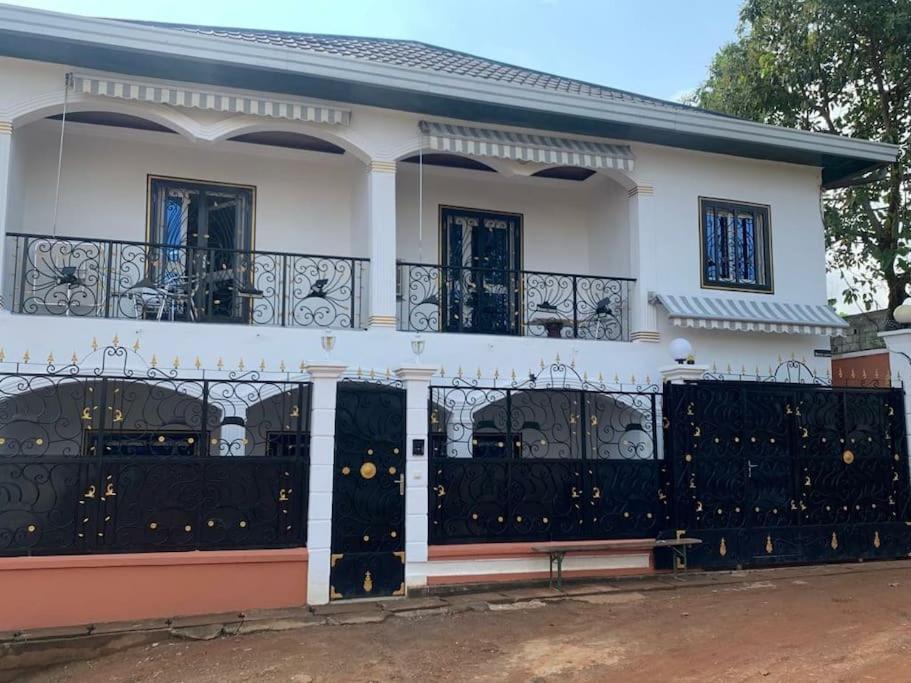 a white house with a black iron gate at Villa luxueuse - Odza - Yaoundé in Yaoundé