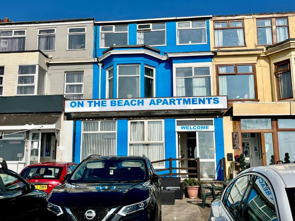 a blue building with a sign that reads on the beach apartments at On The Beach Apartments in Blackpool
