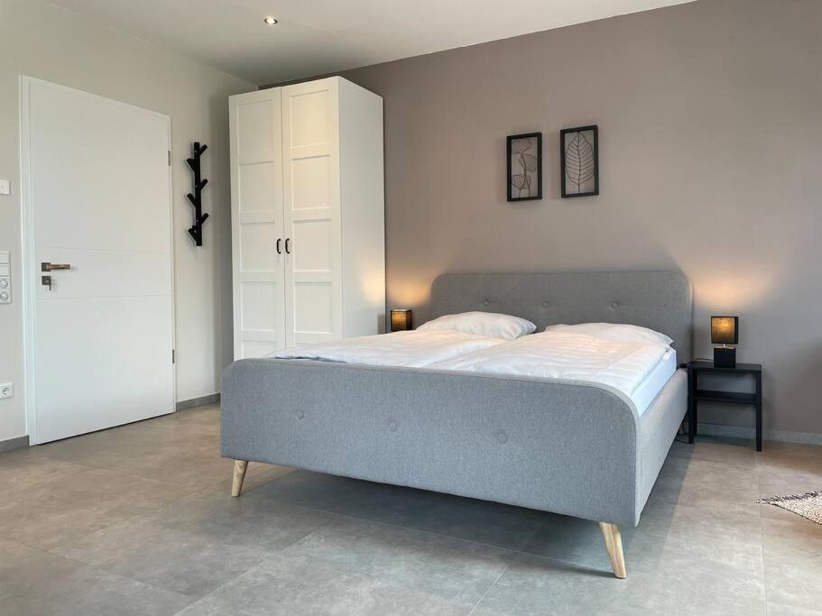 ein Schlafzimmer mit einem großen Bett mit zwei Lampen in der Unterkunft Studio - Apartment Steinmetz mit Balkon in Reken