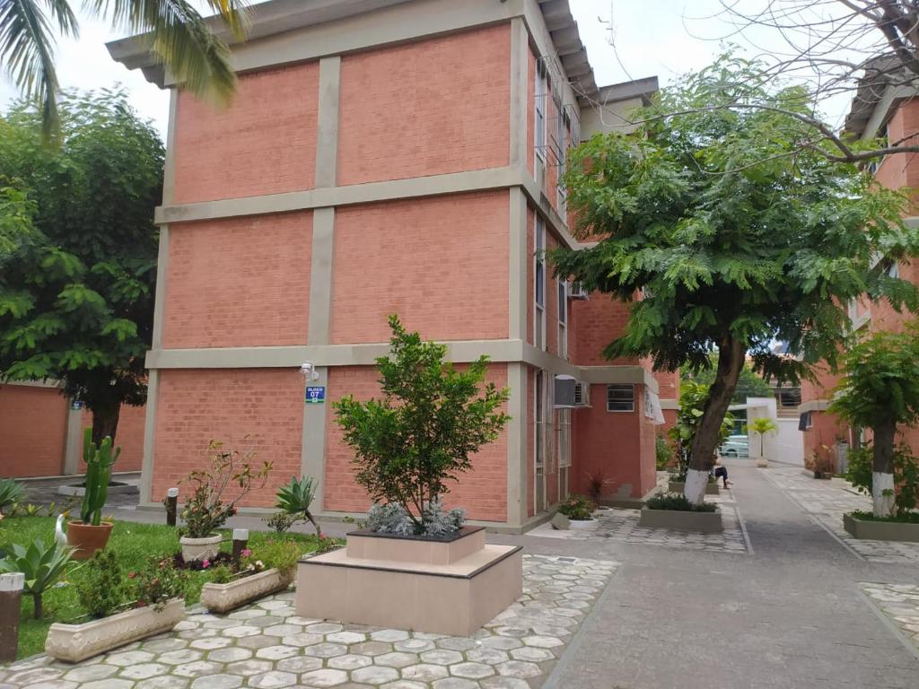 a brick building with trees in front of it at Apartamento Paraíso das Dunas em Cabo Frio in Cabo Frio
