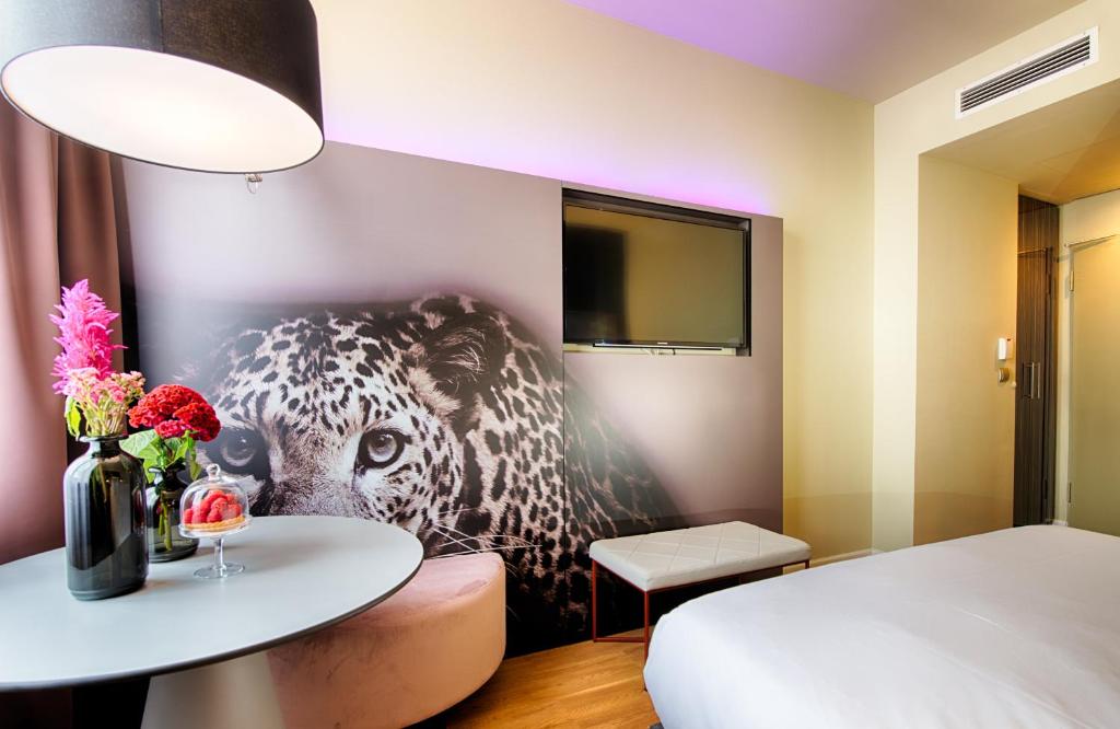 NYX Hotel Mannheim by Leonardo Hotels في مانهايم: غرفة نوم فيها صورة فهد على الحائط