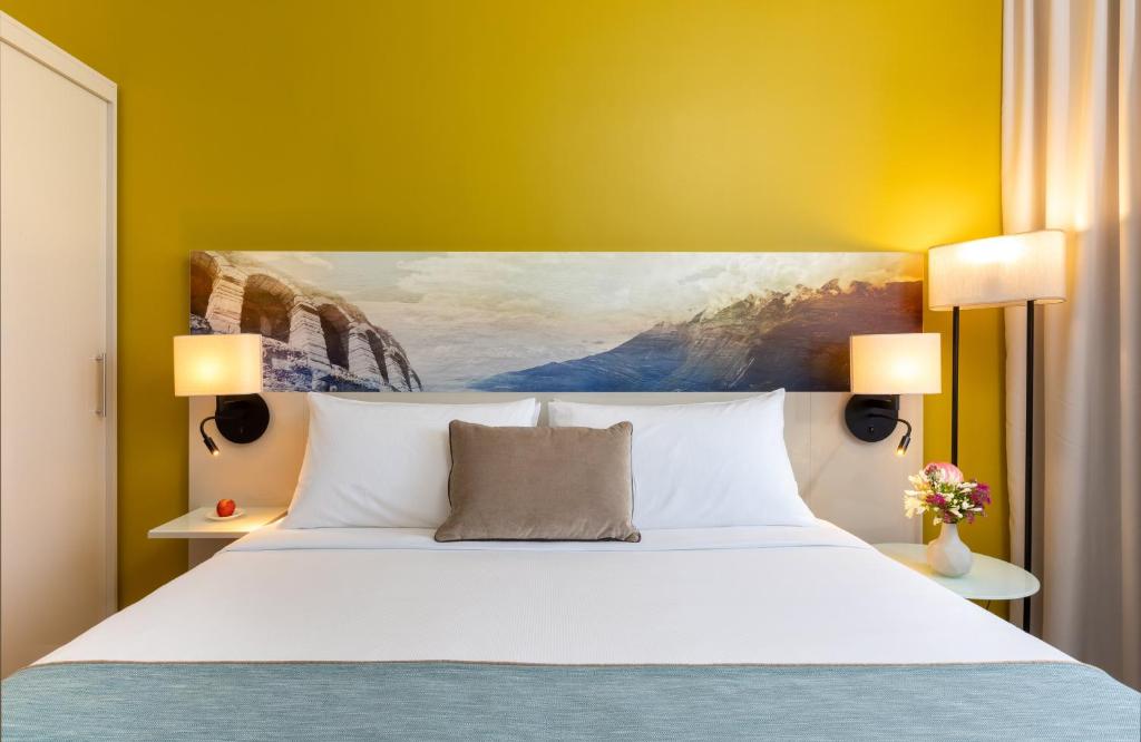 A bed or beds in a room at Leonardo Hotel Verona