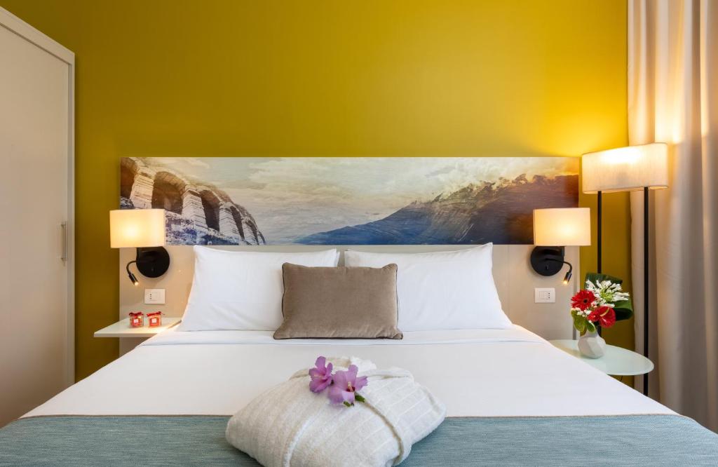 A bed or beds in a room at Leonardo Hotel Verona