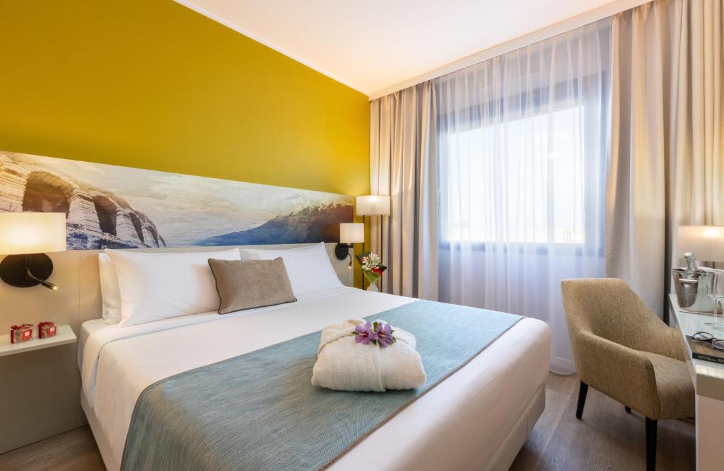 A bed or beds in a room at Leonardo Hotel Verona