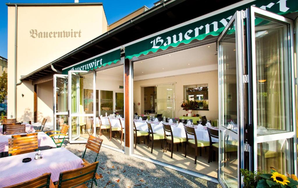 restauracja ze stołami i krzesłami wewnątrz budynku w obiekcie Bauernwirt w Grazu