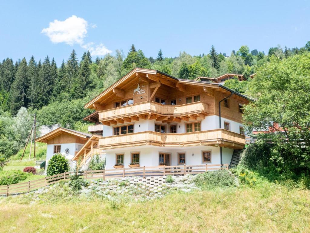 una casa en una colina con árboles en el fondo en Alpensteinbock Saalbach C en Saalbach Hinterglemm