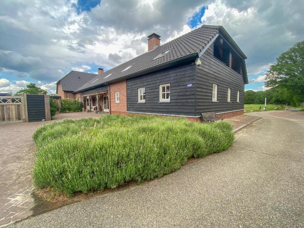 una casa con un patio de hierba delante de una casa en Lodge Slabroek, en Uden