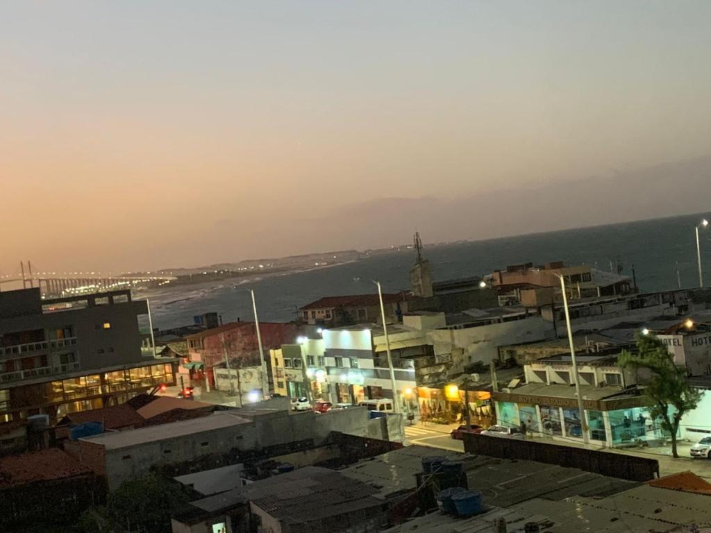 a city with buildings and the ocean in the background at Solar Areia Preta 302 in Natal