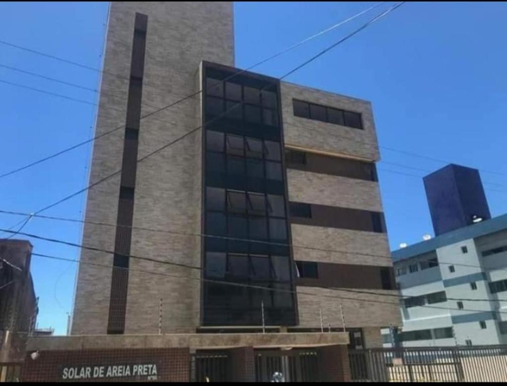 a tall brick building with a sign on it at Solar Areia Preta 302 in Natal