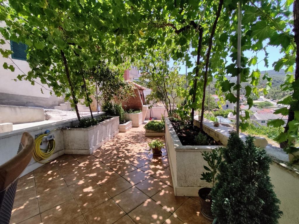 a courtyard with trees and plants in a building at Apartments by the sea Povlja, Brac - 5644 in Povlja