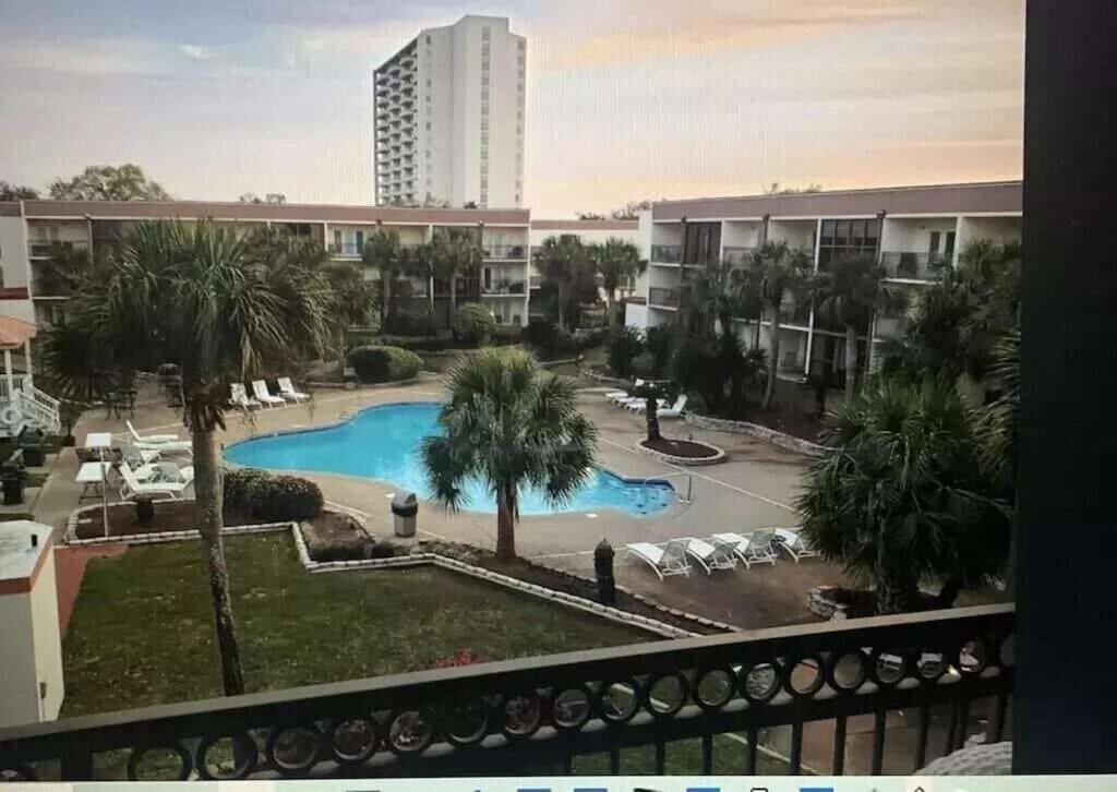 vistas a la piscina desde el balcón de un edificio en Biloxi Beach Condo en Biloxi