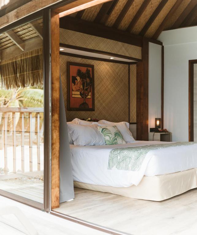 um quarto com uma grande cama branca em um quarto em Maitai Bora Bora em Bora Bora