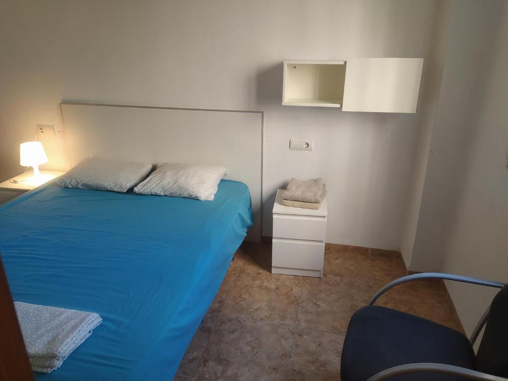 バレンシアにあるApartamento Alguerの小さなベッドルーム(青いベッド1台、椅子付)