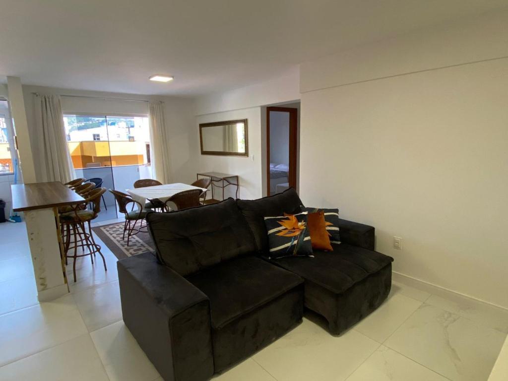 a living room with a brown couch and a table at Apartamento com piscina Condomínio Balneário Camboriú in Balneário Camboriú