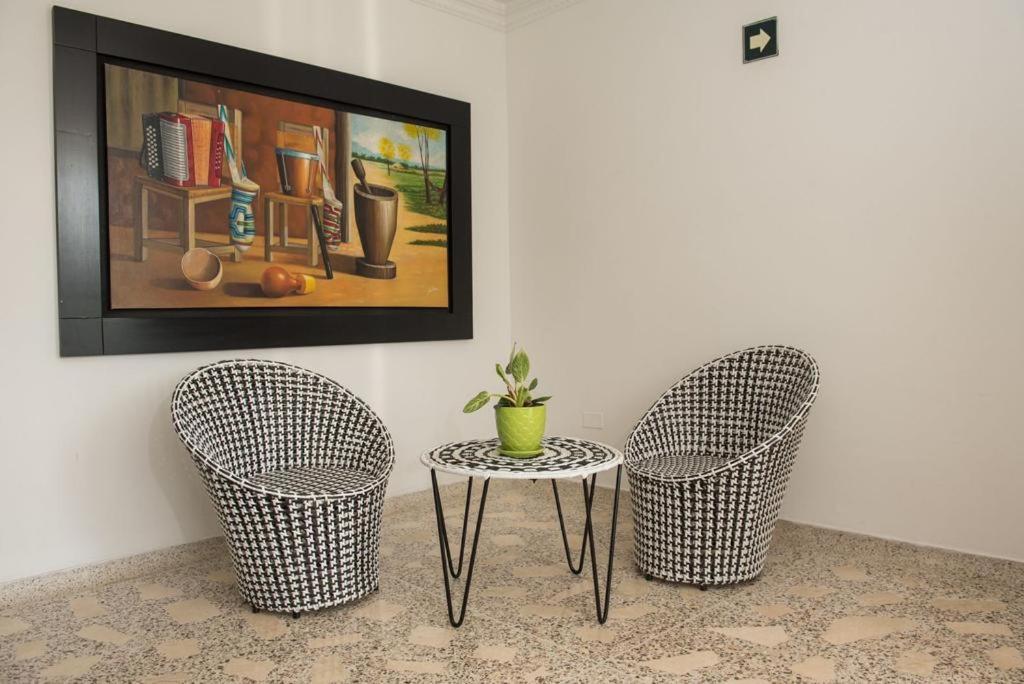 2 sillas y una mesa en una habitación con una foto en Rey de Reyes, en Valledupar