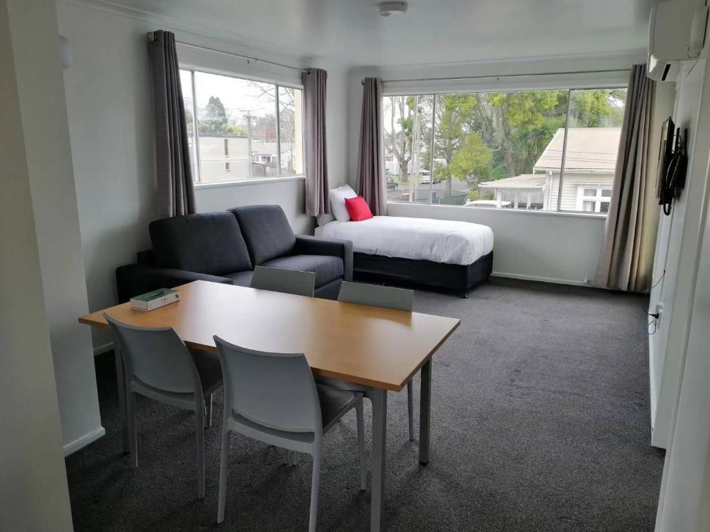 a living room with a couch and a table and a bed at Stanley Apartments in Hamilton