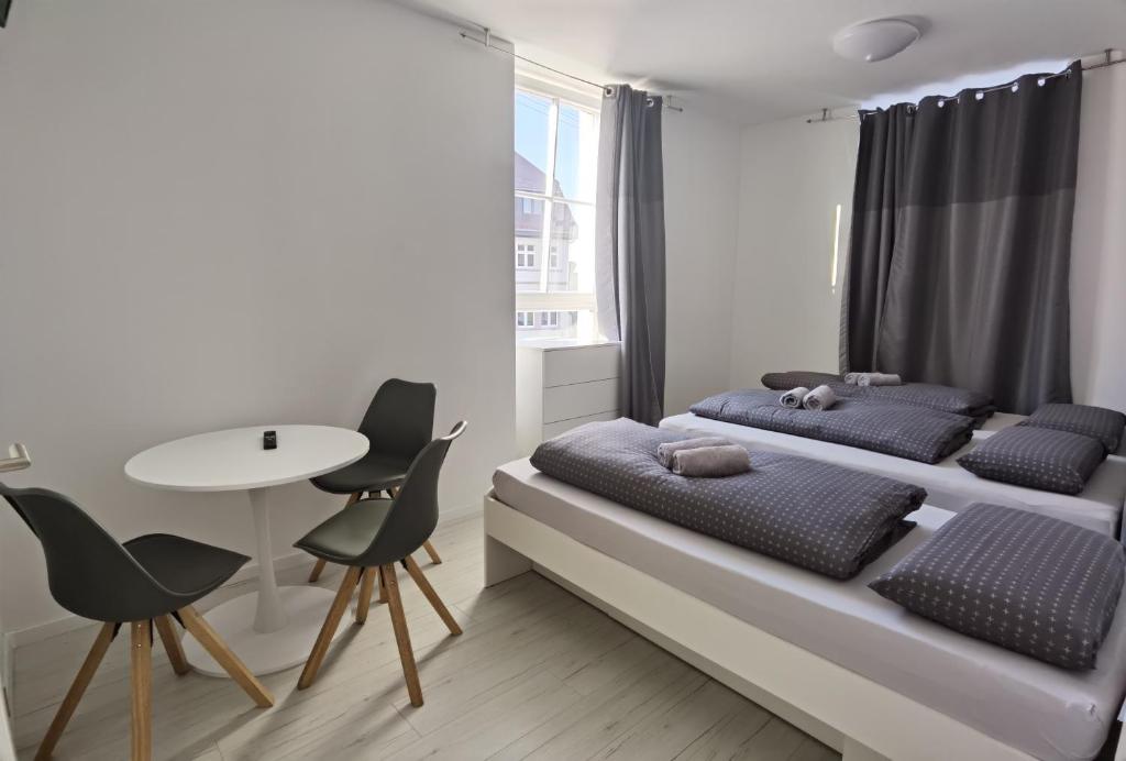 a bedroom with two beds and a table and chairs at Engel Apartments Baden-Baden in Baden-Baden