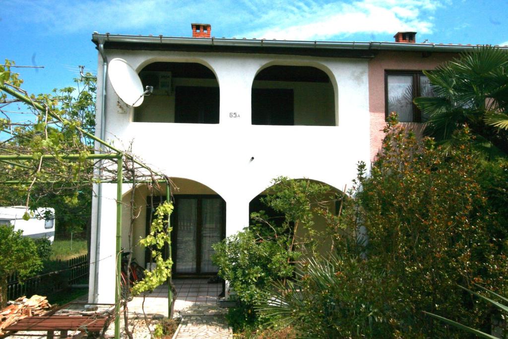 uma casa branca com uma arcada num jardim em Apartments with a parking space Valbandon, Fazana - 15161 em Fažana