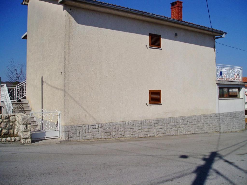 Dobrinj的住宿－Apartments with a parking space Tribulje, Krk - 15223，两扇窗户的白色建筑