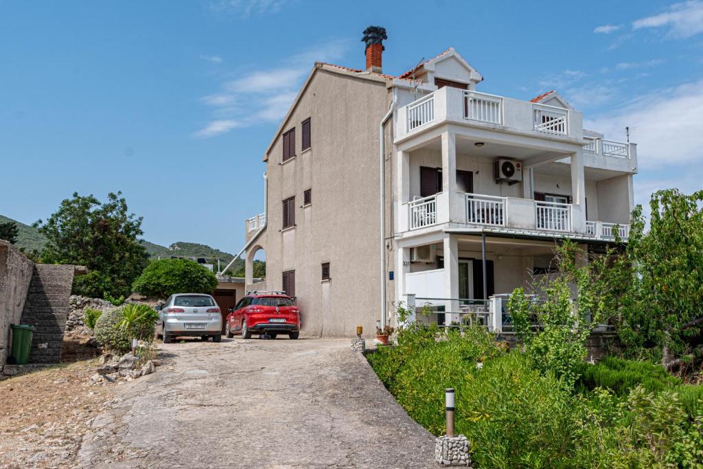 um edifício com carros estacionados em frente em Apartments by the sea Kneza, Korcula - 10168 em Racisce