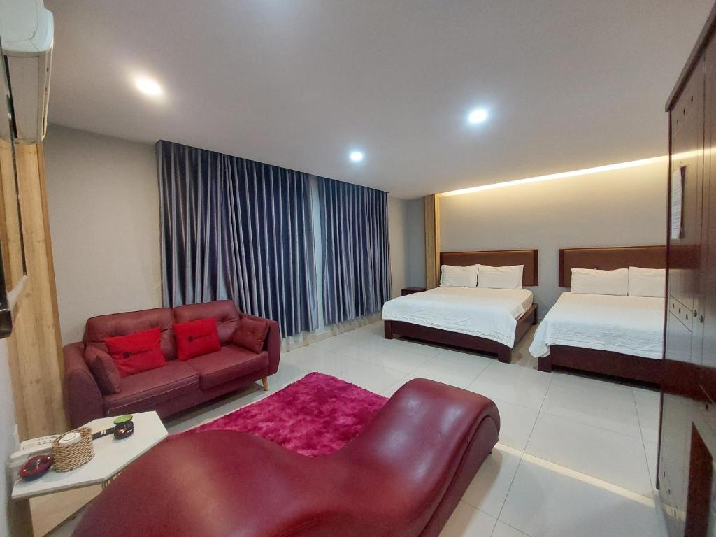 Habitación de hotel con 2 camas y sofá en ABC HOTEL BÌNH TÂN, en Ho Chi Minh