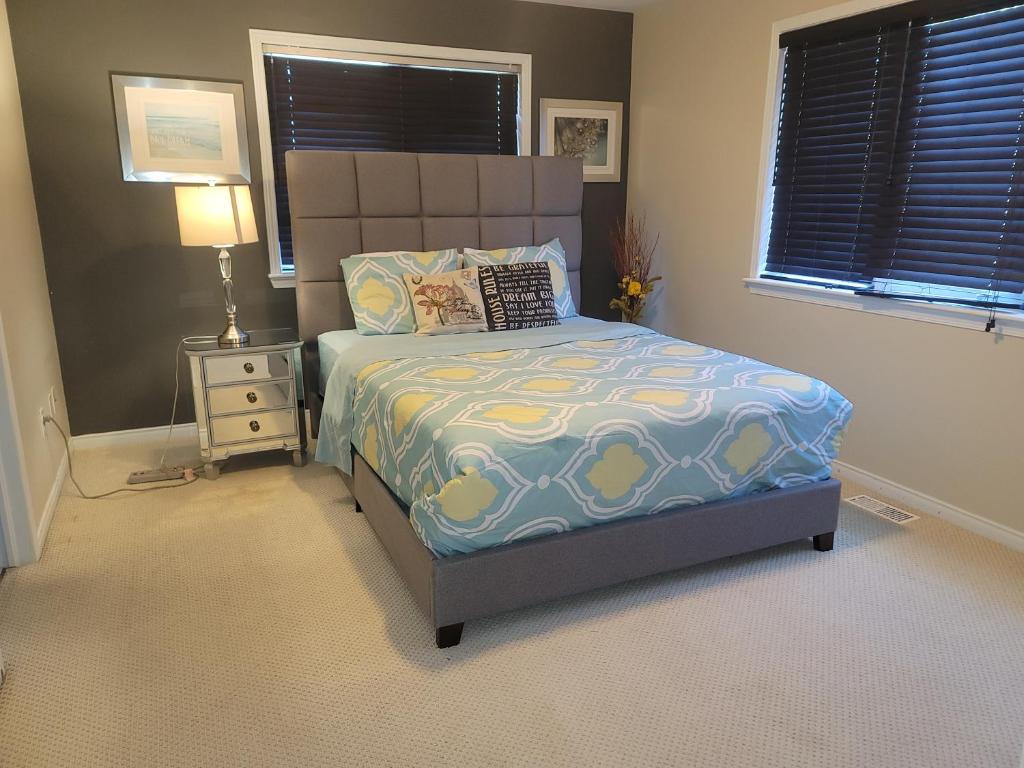 a bedroom with a bed and a night stand with a lamp at Mannys place in Nepean