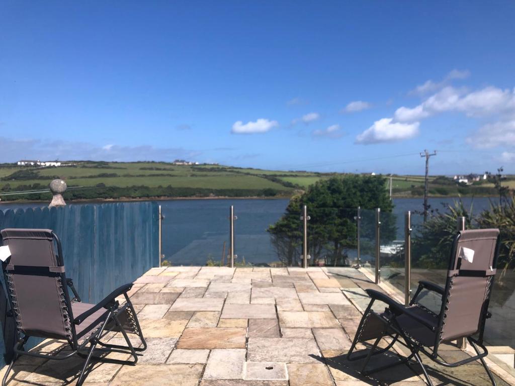 two chairs on a patio with a view of a lake at Centrally located coastal townhouse Belmullet in Belmullet
