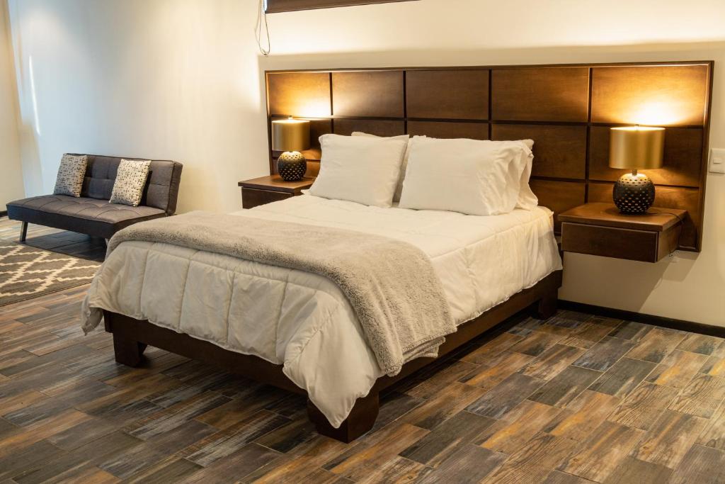 um quarto com uma cama grande e uma cadeira em Estancias Sierravita em Valle de Guadalupe