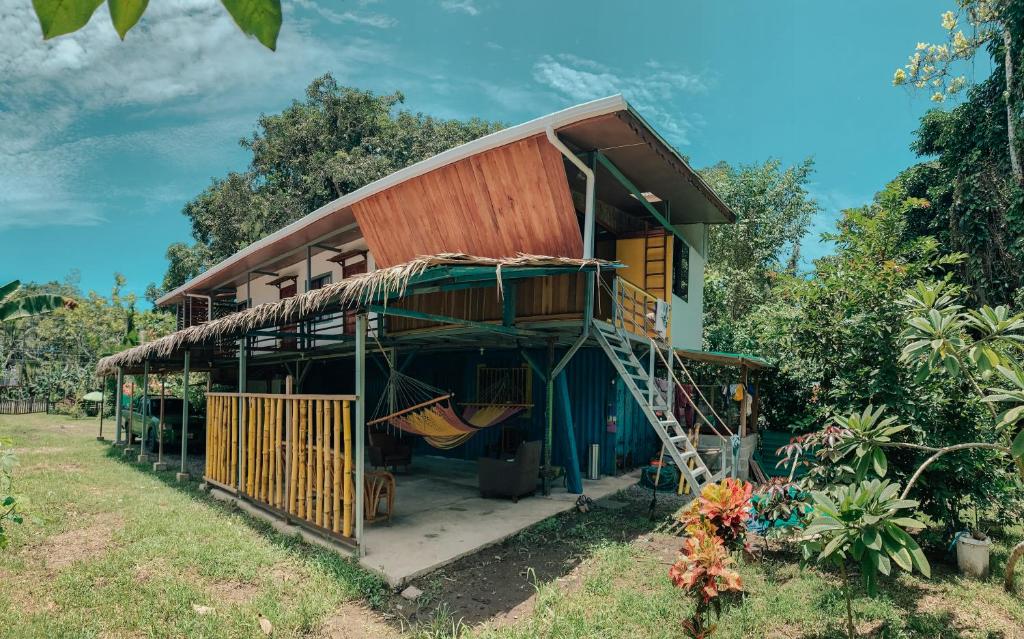 a house with a hammock in the front of it at Orgánico Punta Riel in Cahuita