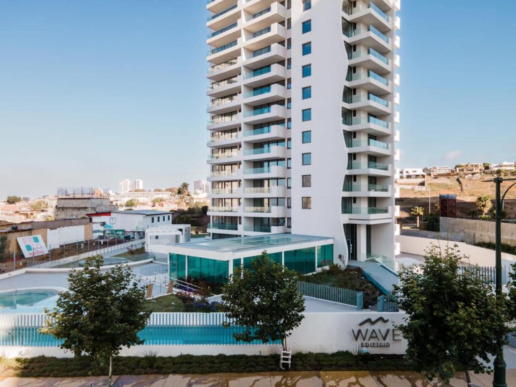 un edificio con piscina frente a un edificio en Edificio WAVE Costa Montemar concon, en Concón