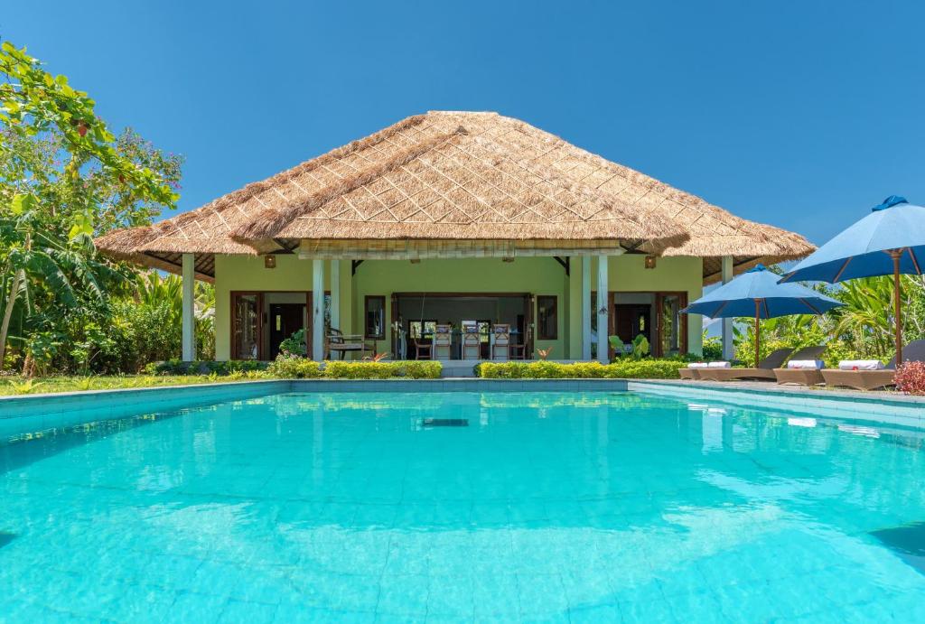 a swimming pool in front of a villa at The North Cape Beach Villas in Umeanyar