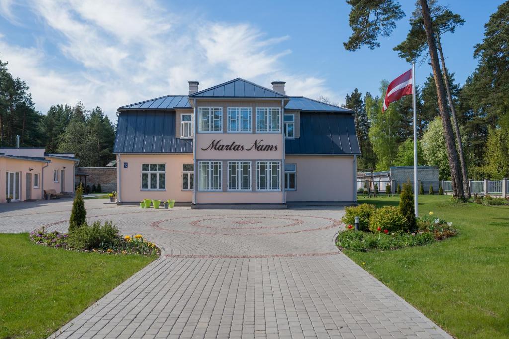 ein Gebäude mit einer Flagge davor in der Unterkunft Martas Nams in Ventspils