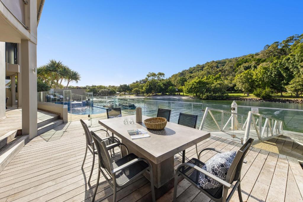 einen Tisch und Stühle auf einer Terrasse mit Flussblick in der Unterkunft 31 Witta Circle, Noosa Heads in Noosa Heads