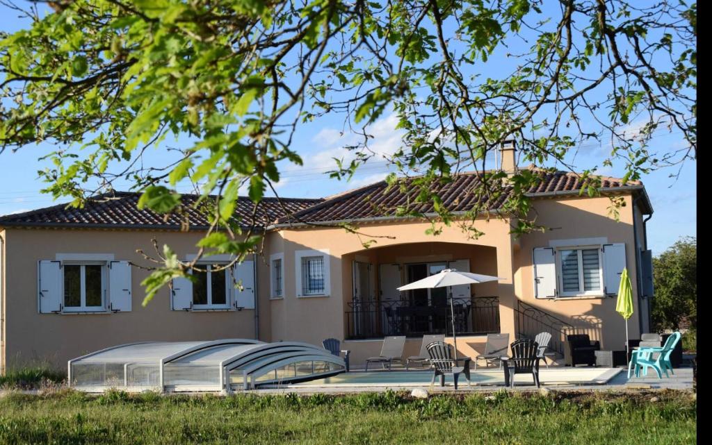 a house with a patio in front of it at Villa de charme avec piscine couverte et 2500m2 de terrain in Lablachère