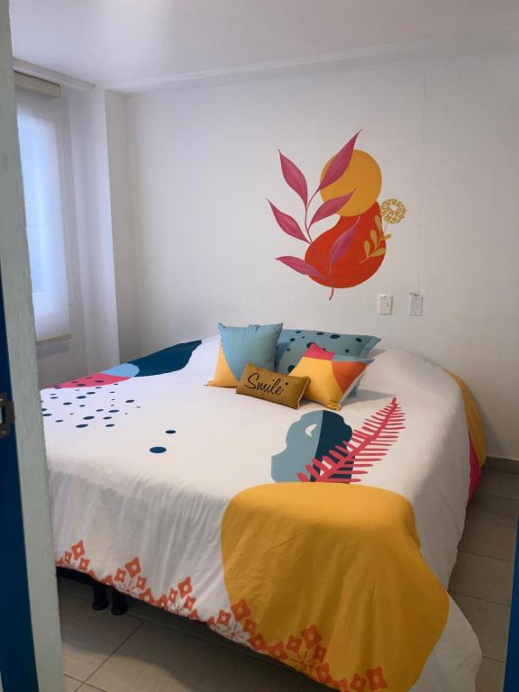 a bedroom with a large bed with colorful pillows at Hostal Casa Lantana La Candelaria in Bogotá