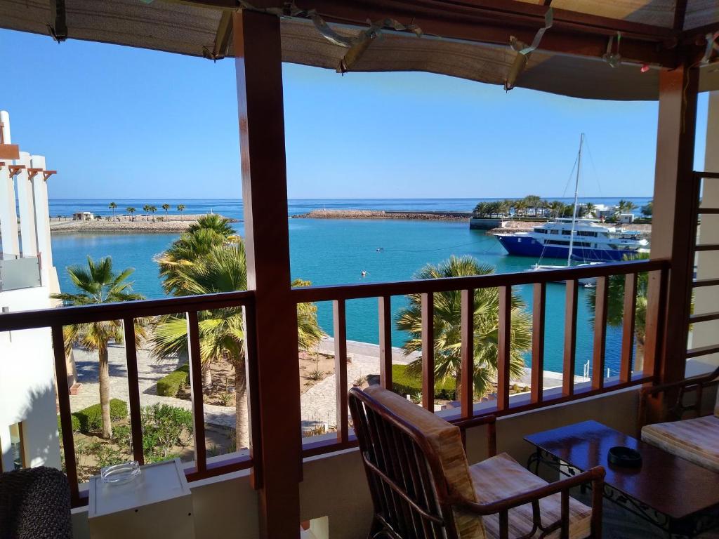 einen Balkon mit Meerblick und einem Boot in der Unterkunft NomadTours Marina Apartment Jebel Sifah in As Sīfah